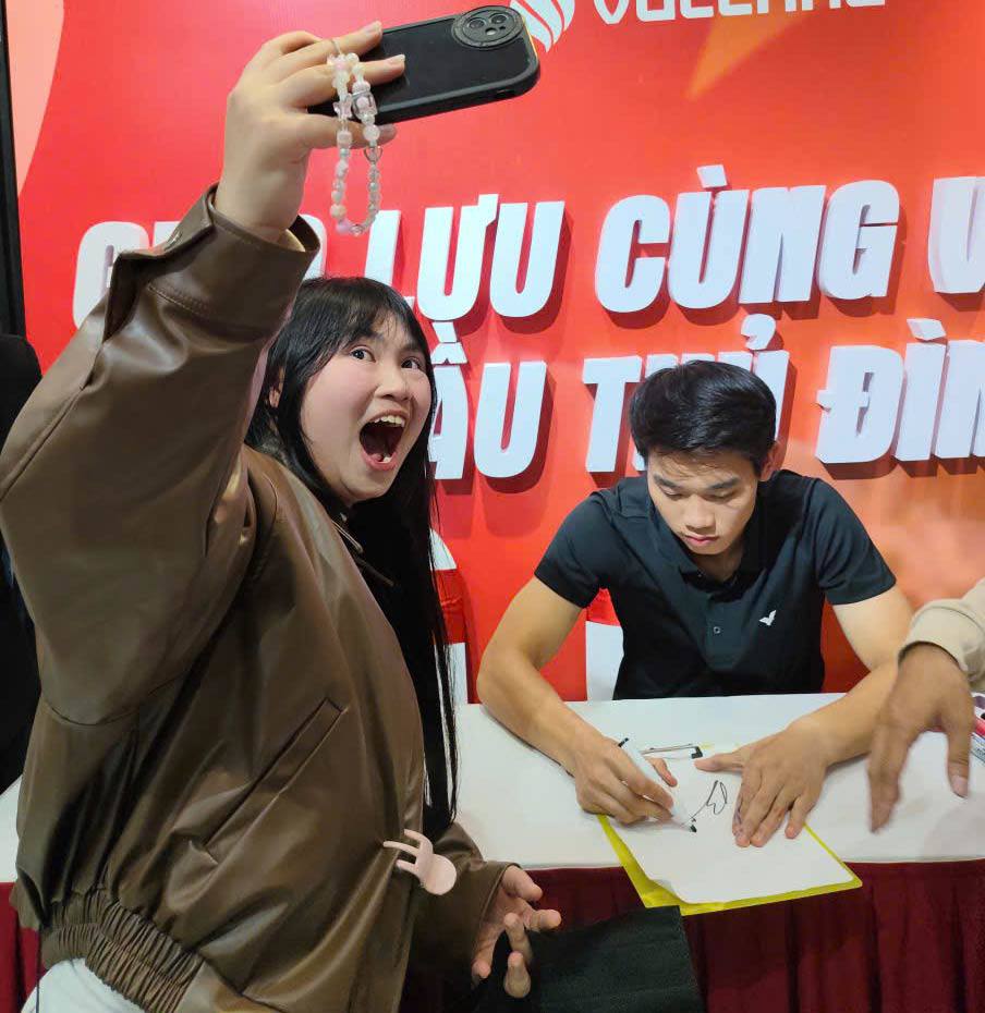 Cô gái trẻ tranh thủ chụp ảnh cùng thần tượng khi xin chữ kí.